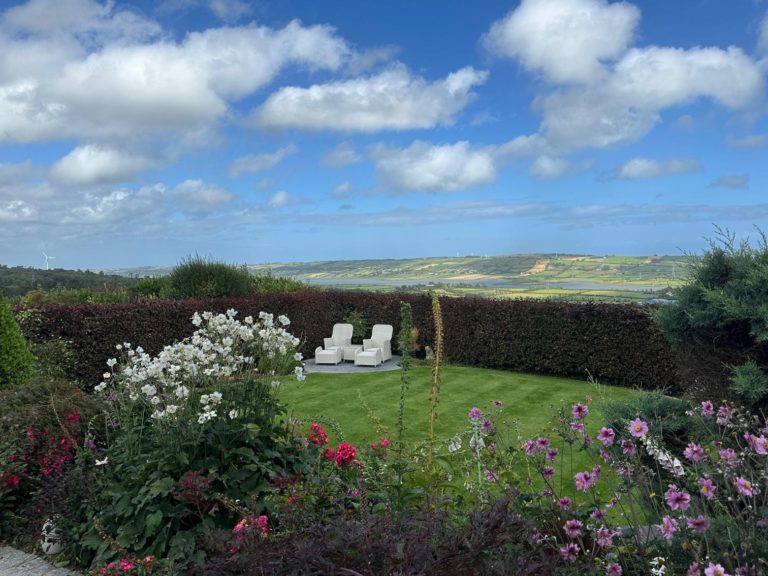 Striped lawn and seating area in a Ballycarry garden looked after by Premier Lawns