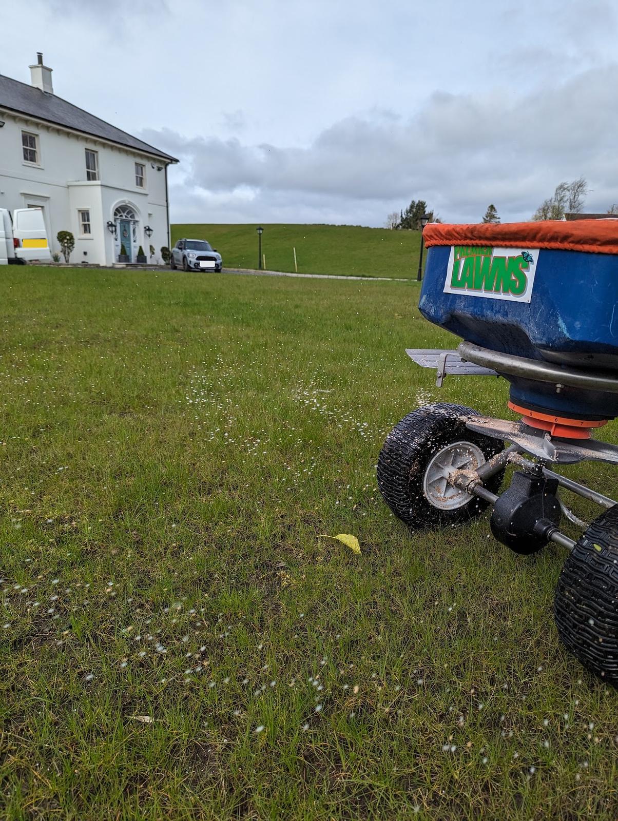 Premier Lawns spreader putting down a spring feed on a large lawn
