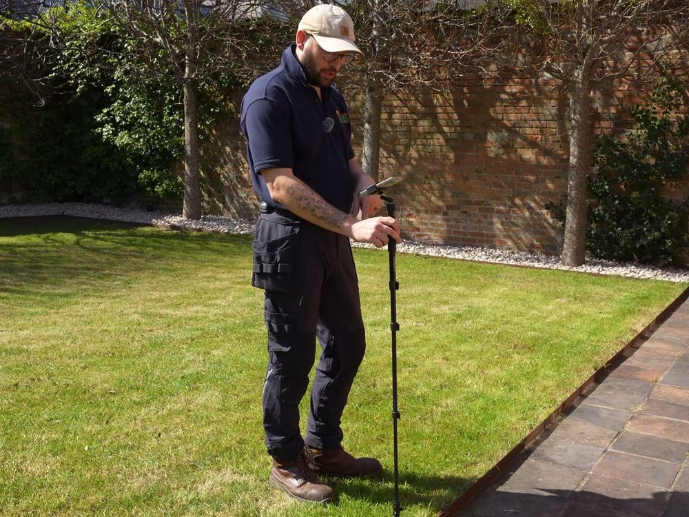 Premier Lawns team member measuring a client's lawn on a first visit