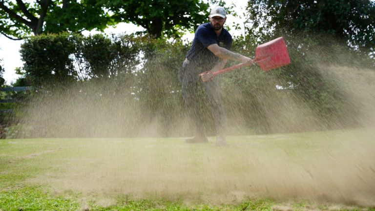 Spreading topdressing to level a lawn